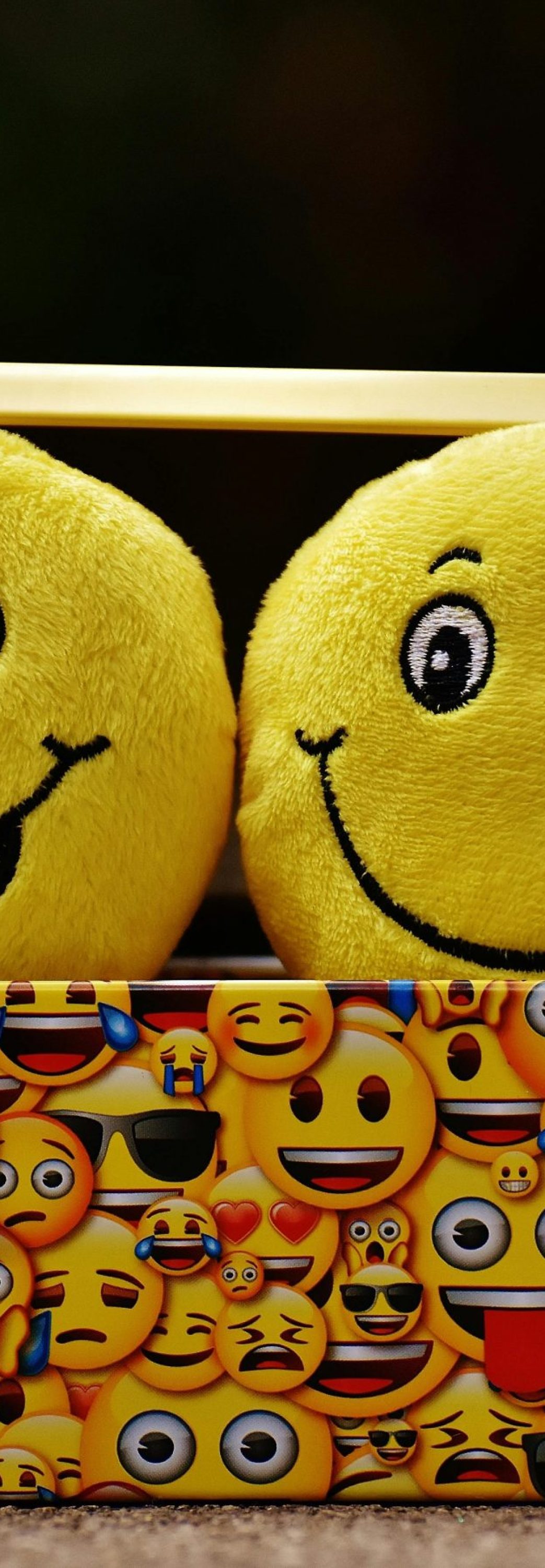 Two yellow smiley plush toys in an emoji-themed box, expressing fun and happiness.