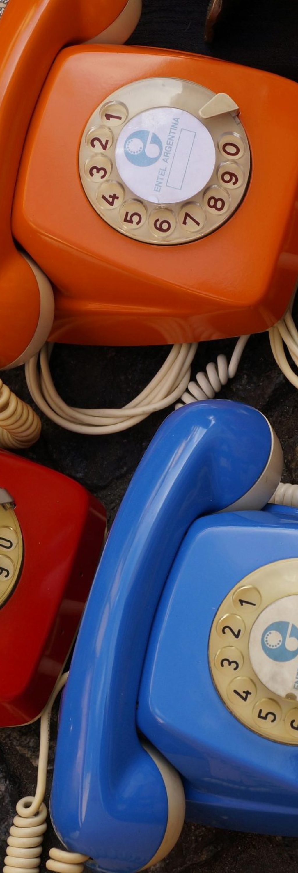 A collection of colorful vintage rotary telephones evokes nostalgic charm and retro style.